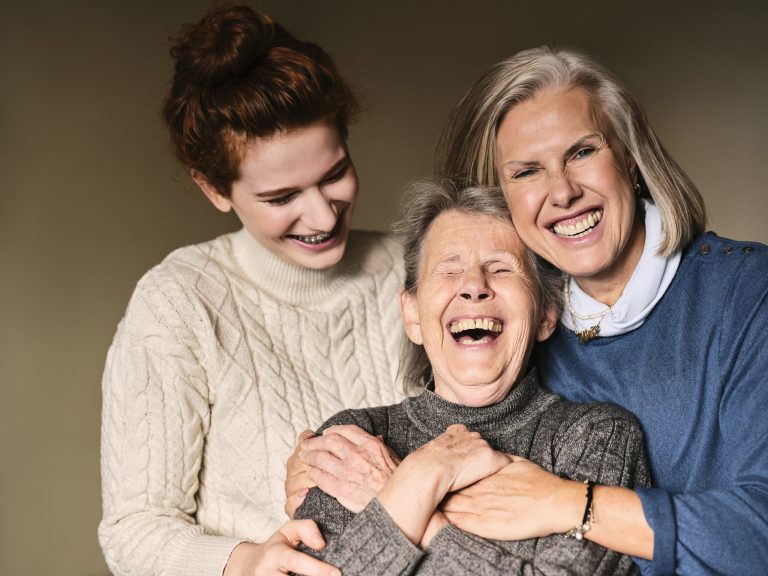 Drei Frauen unterschiedlichen Alters umarmen sich