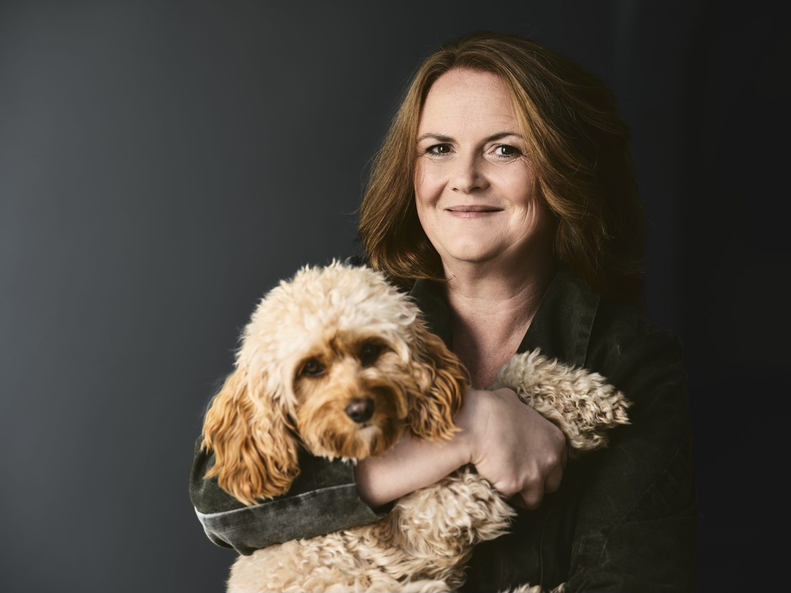 Fröhliche Frau mit deinem Hund am Arm.
