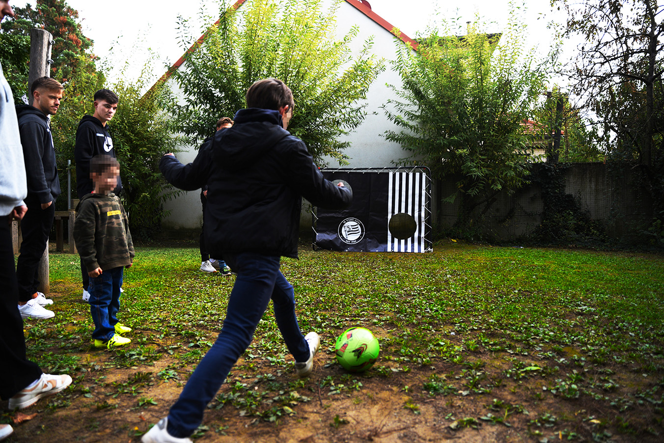 Kinder spielen, im Garten des Frauenhauses, Fußball mit den Spieler:innen des SK Sturm Graz.