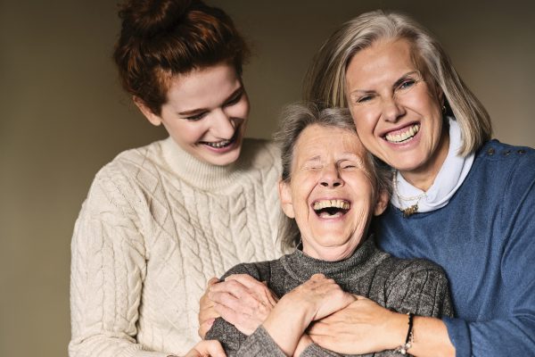 Drei Frauen unterschiedlichen Alters umarmen sich