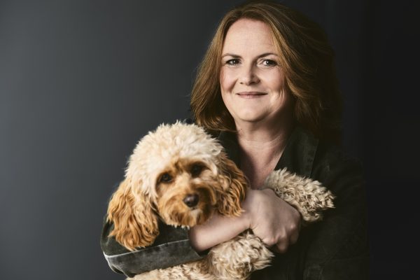 Fröhliche Frau mit deinem Hund am Arm.