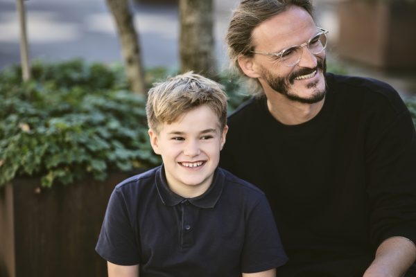 Fröhlicher Bub und Mann sehen zur Seite